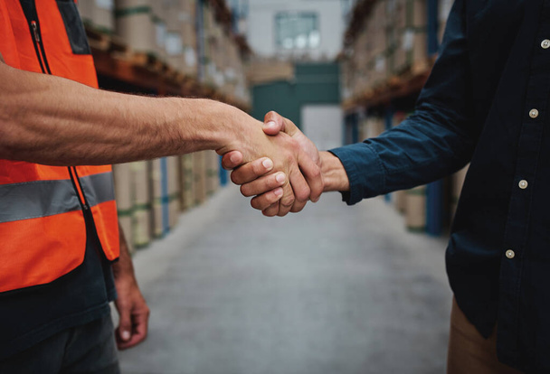 Close-up of two men handshake while concluding agreement about container rent and shaking hands - Foto, imagen