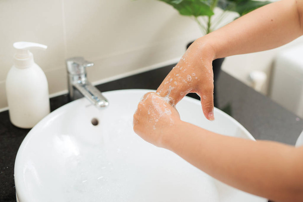 Мыть женщине пальцы с мылом под краном с водой
 - Фото, изображение