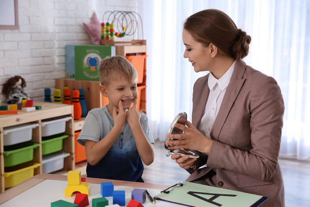 Terapeuta del habla trabajando con un niño en la oficina - Foto, imagen