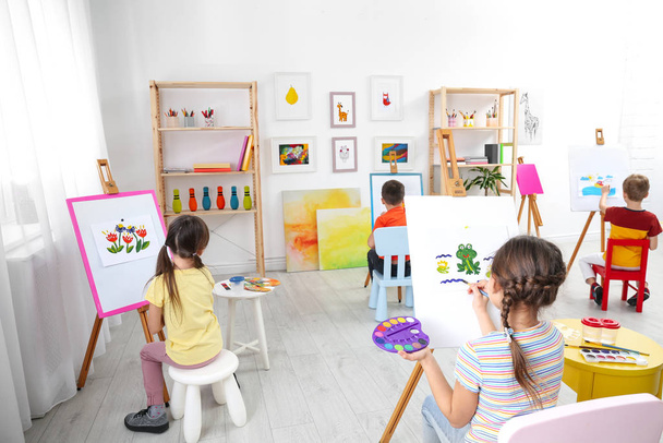 Aranyos kisgyerekek festeni tanítás közben a szobában - Fotó, kép