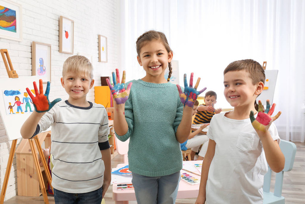 Cute little children with painted palms in room - Foto, Imagen