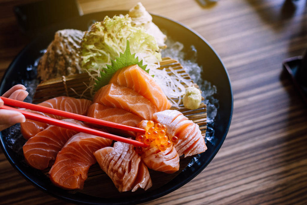Filet de saumon cru avec œufs Ikura sur plat au restaurant, Nourriture japonaise, Gros plan
 - Photo, image