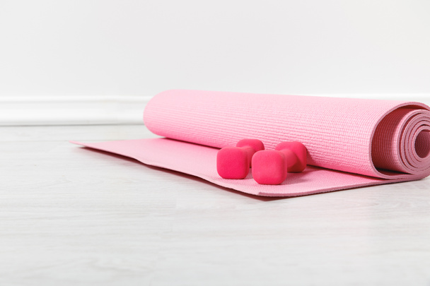 fitness mat and pink dumbbells on floor - Fotoğraf, Görsel