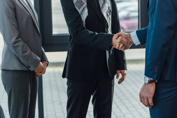 cropped view professional businessmen shaking hands and having deal in modern office - Фото, зображення