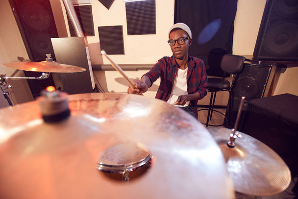 Fisheye-Porträt eines jungen afroamerikanischen Mannes, der bei Proben oder Konzerten im Studio Schlagzeug spielt, Kopierraum - Foto, Bild