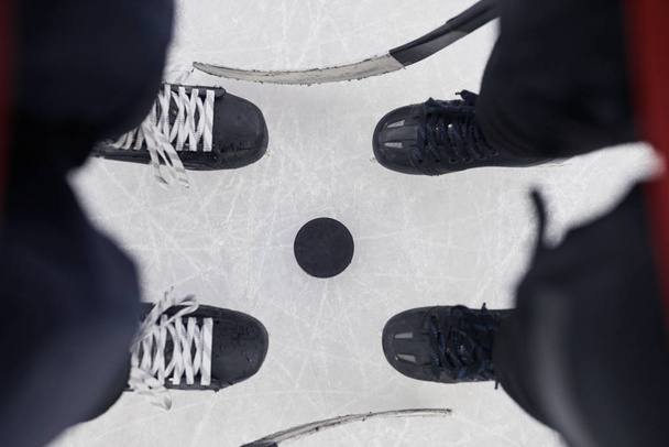 Edellä näkymä tausta kaksi tunnistamatonta jääkiekkoilijat seisoo yli nyppiä valmis aloittamaan ottelun jäällä, kopioi tilaa
 - Valokuva, kuva