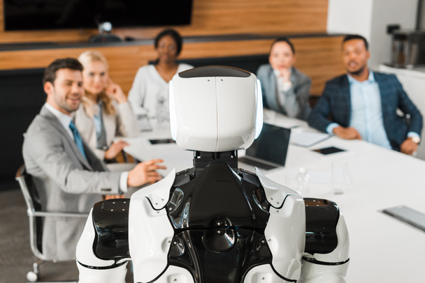 Konferans salonunda robota bakan çok kültürlü iş adamlarının seçici odağı - Fotoğraf, Görsel