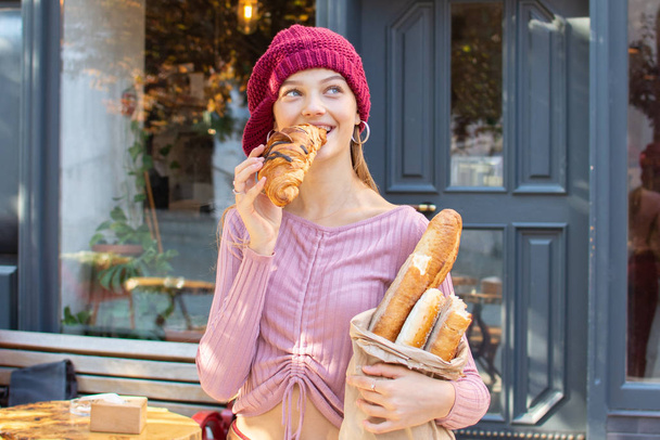 teenager girl eating a fresh croissant - Fotoğraf, Görsel