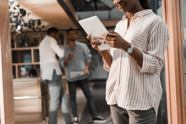 обрезанный взгляд африканских американских бизнесвумен, использующих цифровые планшеты вблизи мультикультурных коллег
 - Фото, изображение