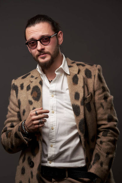 Male in sunglasses in jacket on brown background - Fotoğraf, Görsel
