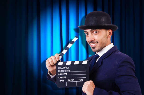 Mann mit Filmklöppel auf Vorhang-Hintergrund - Foto, Bild