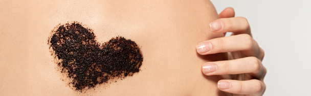 panoramic shot of woman with heart sign of coffee scrub on body, isolated on grey - Photo, Image