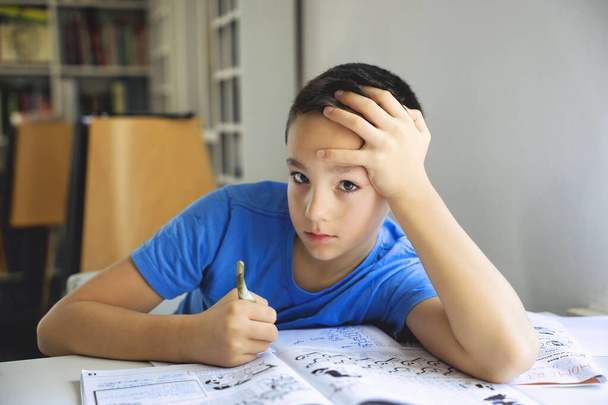 Jeune garçon écrit devoirs
. - Photo, image