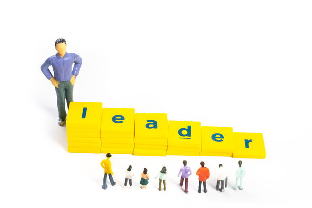 Siga al líder - concepto de trabajo en equipo. Figuras miniatura, blanco
 - Foto, Imagen