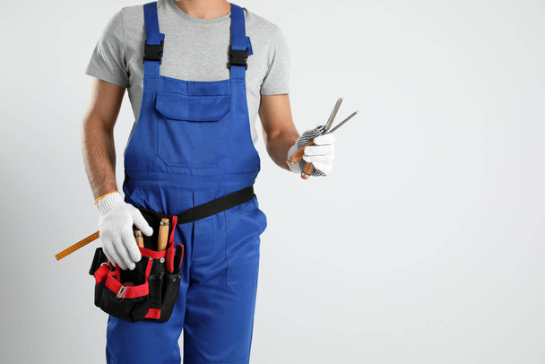 Carpenter with tool belt and chisels on light background, closeu - Photo, image