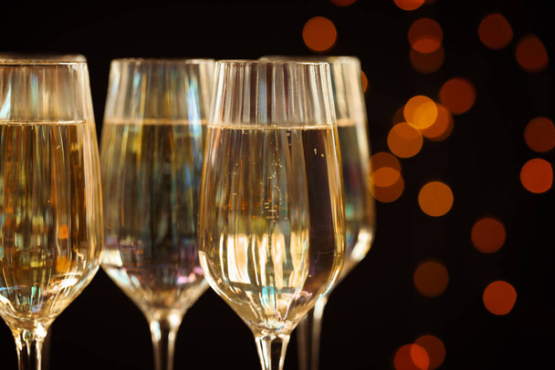 Glasses of champagne against blurred lights, closeup - Photo, image