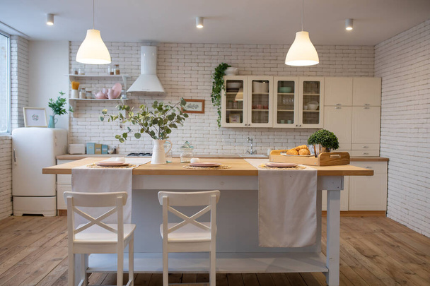 Modern white kitchen in scandinavian style. Open shelves in the kitchen with plants and jars - 写真・画像