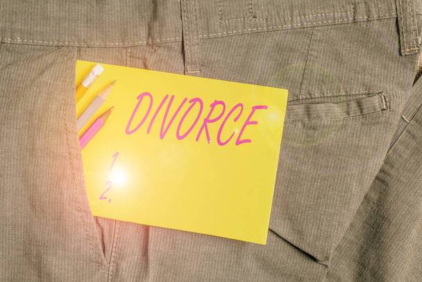 離婚を示すメモを書く。結婚の法的溶解を示すビジネス写真分離ブレークアップ意見の不一致男のズボンのポケットの中に筆記具と黄色のノートペーパー. - 写真・画像