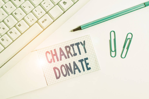 Conceptual hand writing showing Charity Donate. Business photo text gift made by an individual to a nonprofit organization White pc keyboard with paper and paper clip above white background. - Photo, Image