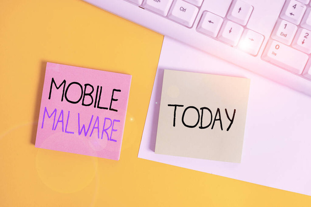 Kézírás szövegírás Mobile Malware. Koncepció jelentése rosszindulatú szoftver írt támadni mobil eszközök Papír másolási hely és billentyűzet felett narancs háttér asztal. - Fotó, kép