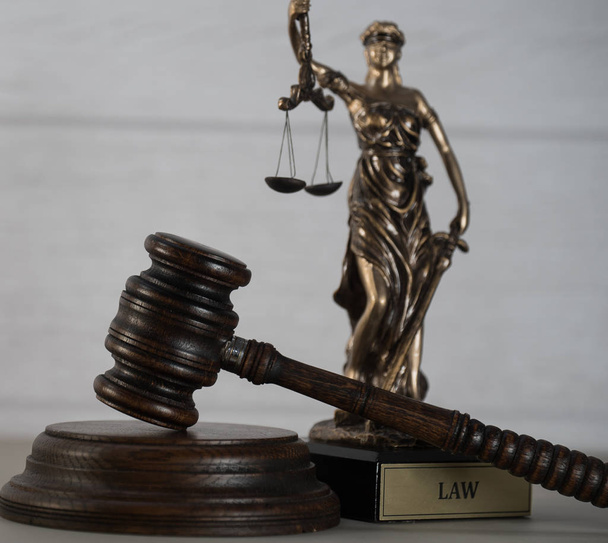κοντινή προβολή, σύμβολα του νόμου και της δικαιοσύνης σε ξύλινο τραπέζι φόντο - Φωτογραφία, εικόνα