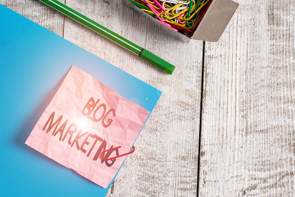 Writing note showing Blog Marketing. Business photo showcasing any process that publicises or advertises a website via blog Wrinkle paper and cardboard placed above wooden background. - Photo, Image