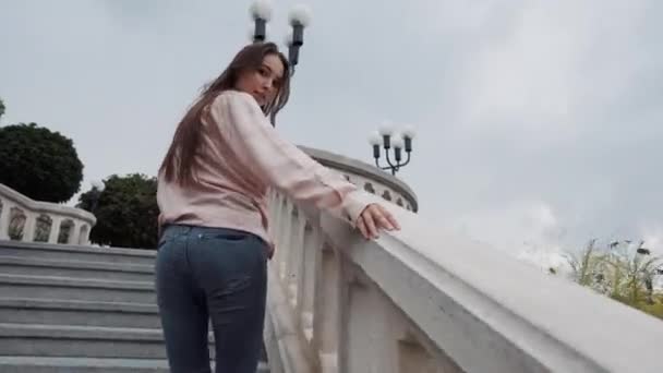 Pretty long-haired girl walking up the stairs outdoors - Footage, Video