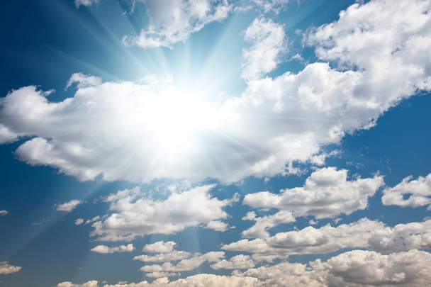 Cielo azul con nubes y rayos de sol
 - Foto, Imagen