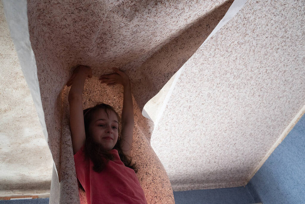 Frau hängt Tapetenmotiv. Teen girl hilft, Tapeten an die Decke zu kleben - Foto, Bild