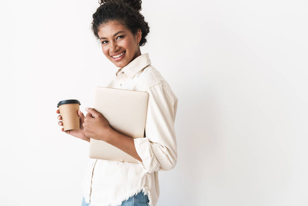 Smiling lovely stylish african woman holding laptop computer - 写真・画像