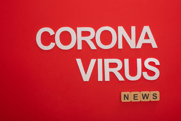 Top view of coronavirus lettering with news inscription on wooden cubes on red background - Φωτογραφία, εικόνα
