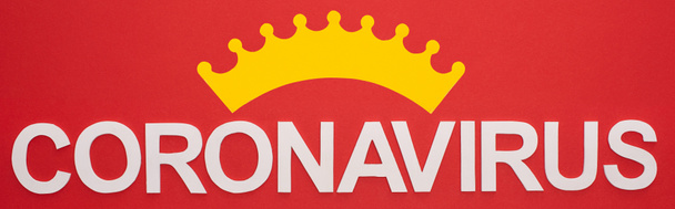 Vue de dessus du lettrage du coronavirus et du signe de la couronne isolés sur un plan panoramique rouge
 - Photo, image