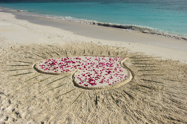 Szerelmi üzenet a homokon, szív szirmokkal egy trópusi szigeten - Fotó, kép