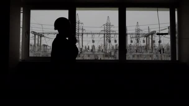 Silueta po okně inženýrských plánů pracovní proces vysílačkou o energetice - Záběry, video