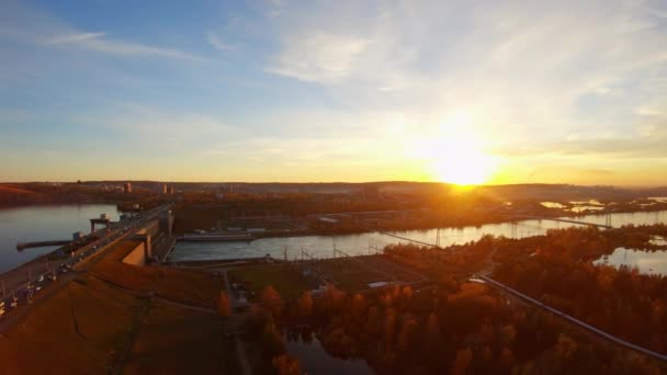 Vista aérea da paisagem urbana industrial: rio, barragem, edifícios ao pôr do sol
 - Filmagem, Vídeo
