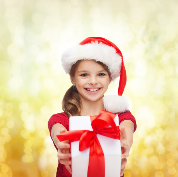 Smiling girl in santa helper hat with gift box - Photo, image