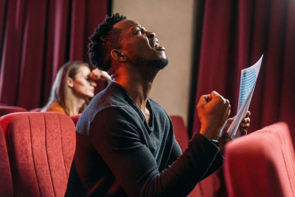 Африканский американский грустный актер кричит и репетирует в театре с молодым актером
 - Фото, изображение