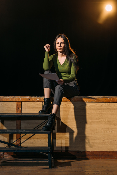 beautiful young actress reading scenario on stage in theatre - Zdjęcie, obraz