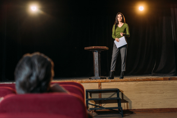 selectieve focus van theaterregisseur en mooie actrice met scenario op het podium - Foto, afbeelding