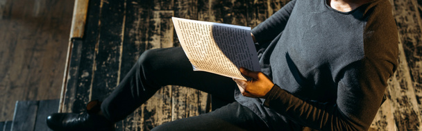 панорамний знімок афроамериканського актора сценарію читання на сцені під час репетиції
  - Фото, зображення