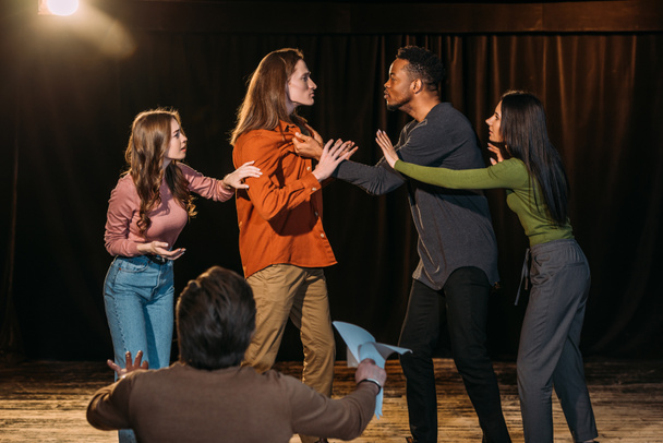 Multikulturelle Schauspieler und Schauspielerinnen proben Kampf auf der Bühne im Theater - Foto, Bild