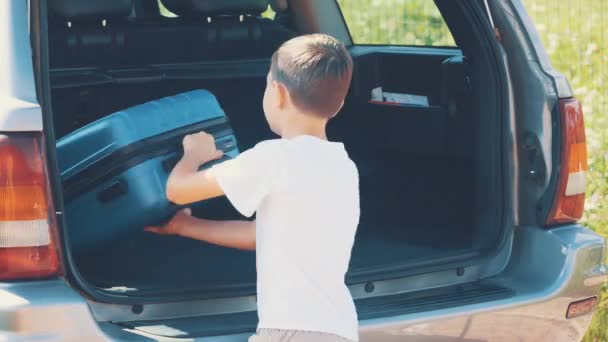 Girl and boy put suitcases into the car boot. Close up. Copy space. 4K. - Imágenes, Vídeo