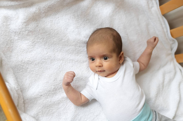 Pasgeboren baby. Een jongetje in witte kleren. Mooi portret van een peuter. Grote ogen baby. - Foto, afbeelding