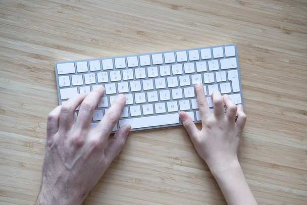 father and son or daughter using the computer keyboard together - 写真・画像