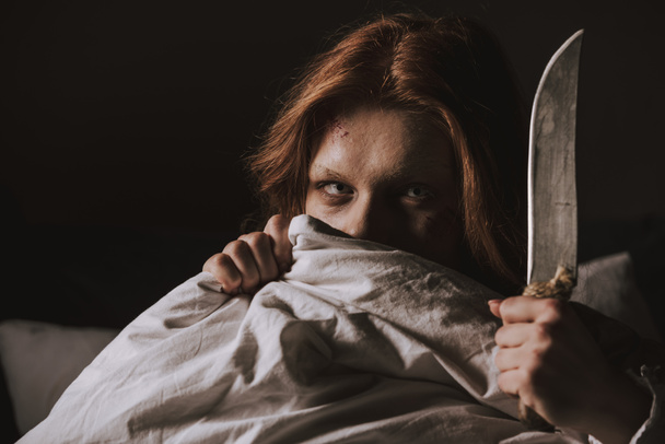 demoniczna opętana zła dziewczyna trzymająca nóż w łóżku - Zdjęcie, obraz