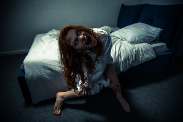 demonic woman in nightgown screaming in bedroom - Photo, Image