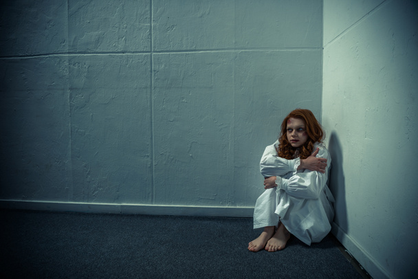 зла дівчина в нічній сорочці, що стоїть біля стіни
 - Фото, зображення