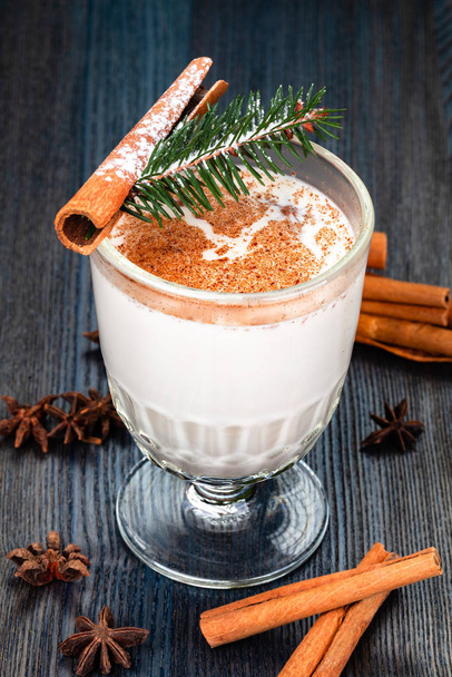 Traditional New Year or Christmas drink eggnog sprinkled  with grated nutmeg and cinnamon in a glass cup. - Photo, Image