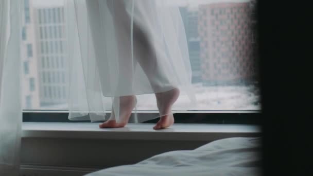 Női lábak az ablak közelében egy felhős téli napon - Felvétel, videó