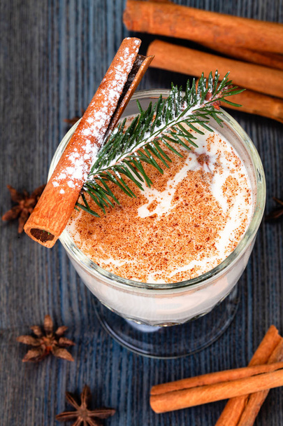 Традиционный новогодний или рождественский напиток, посыпанный тертым мускатным орехом и корицей в стакане
. - Фото, изображение